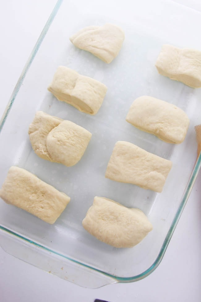 placing dinner roll dough in baking dish
