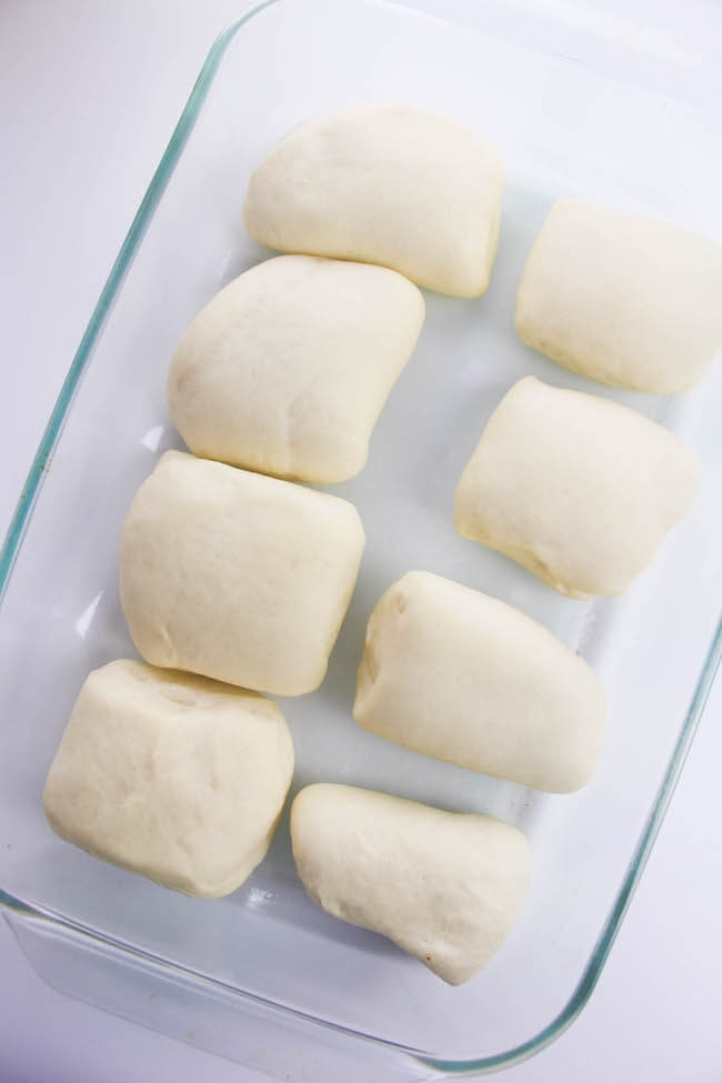 dinner rolls rising in glass baking dish