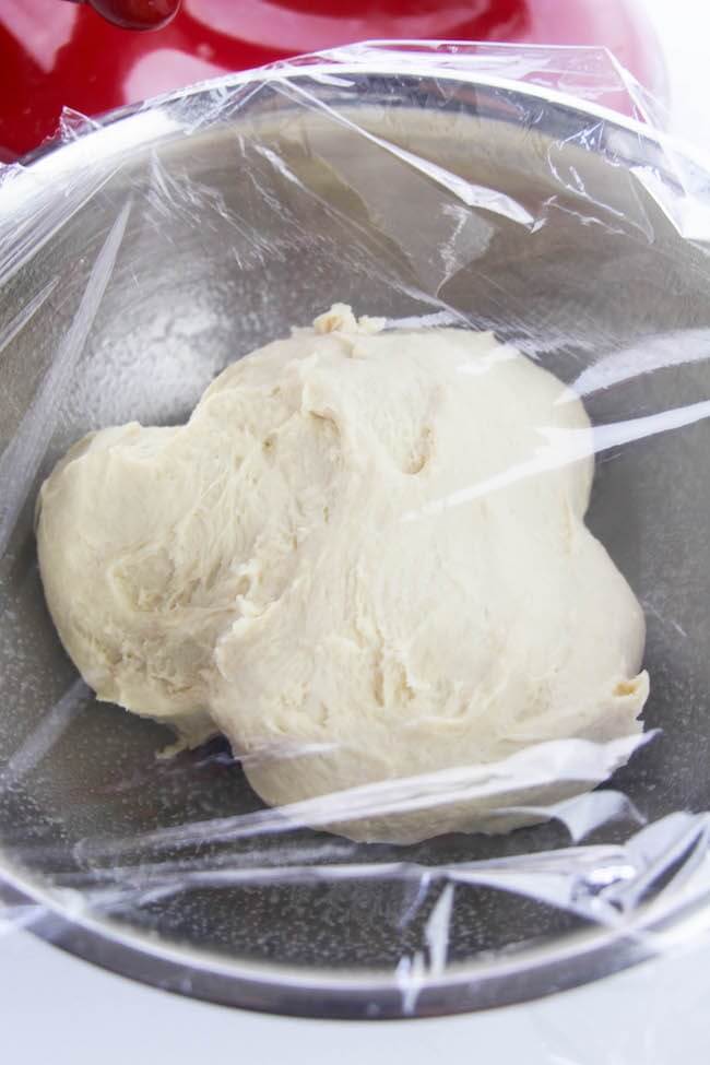 ball of bread dough in metal mixing bowl
