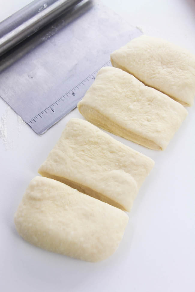 cutting dough into rectangles to make dinner rolls