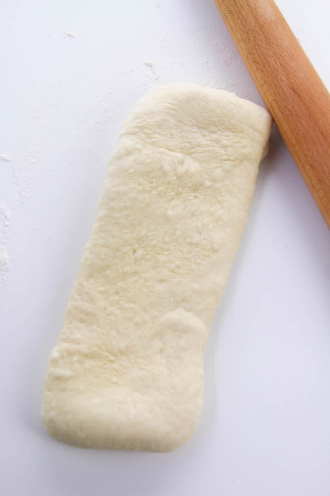 rolling out bread dough into strips