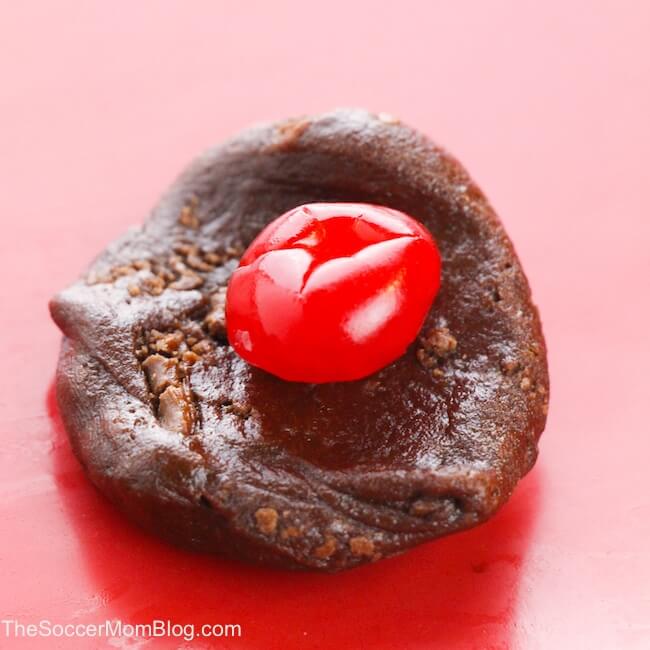 putting cherry in the middle of a chocolate cookie