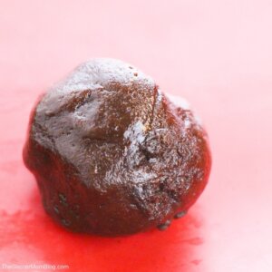 ball of chocolate cookie dough on red baking mat