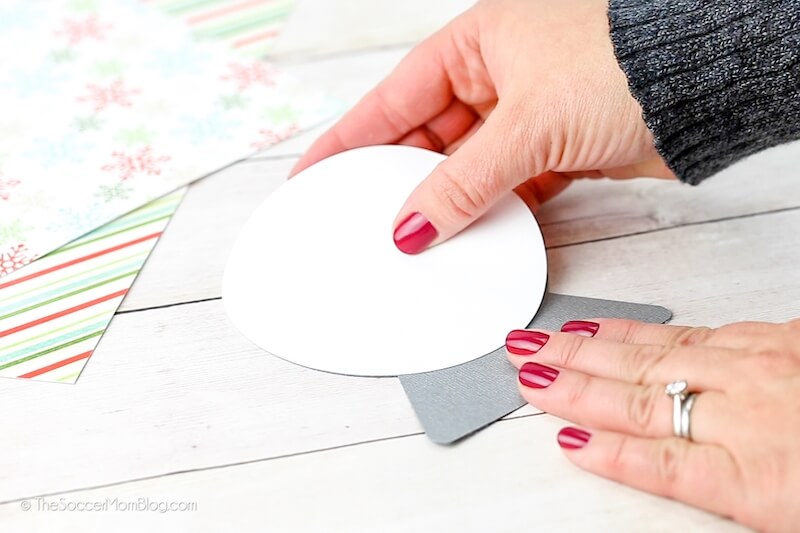 gluing white cardstock to make a paper snow globe ornament