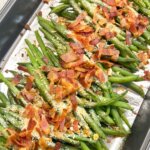 top-down view of a pan of roasted green beans with bacon.