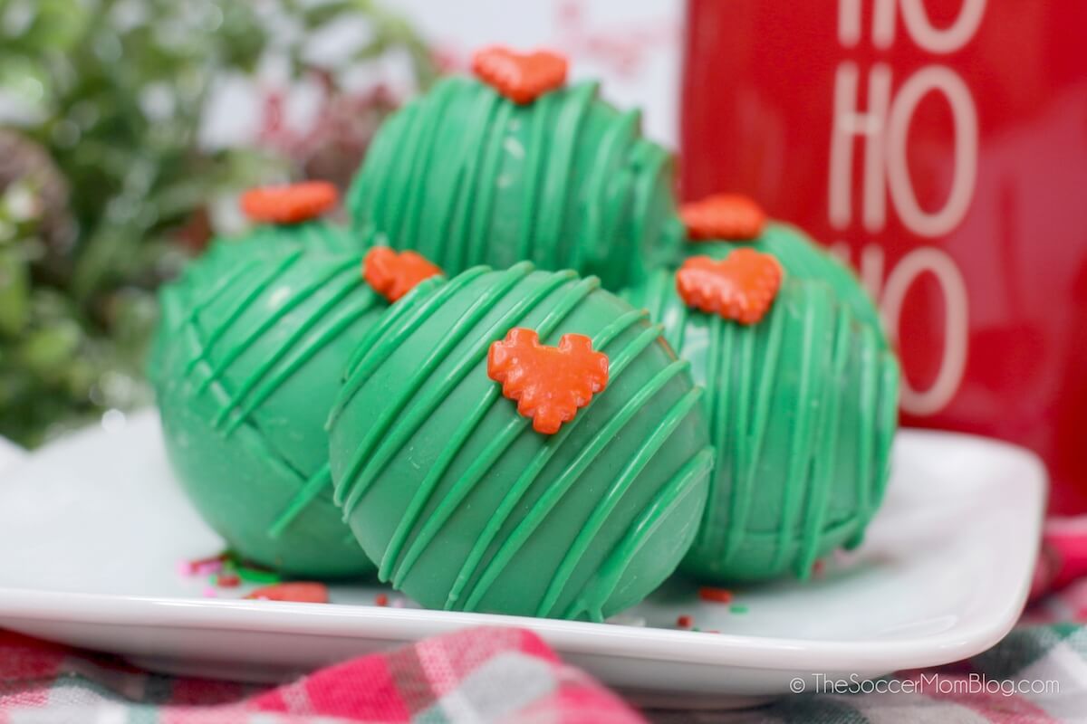 green cocoa bombs with red heart sprinkles, inspired by the Grinch