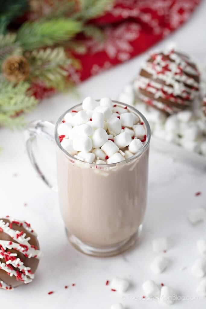 mug full of hot cocoa and marshmallows surrounded by hot cocoa bombs