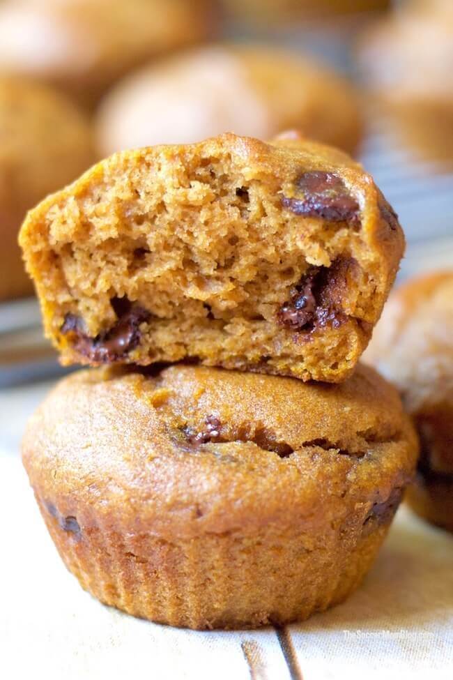 stacked pumpkin muffins, one with bite missing