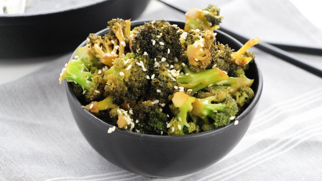 bowl of Chinese style garlic broccoli with chopsticks on table