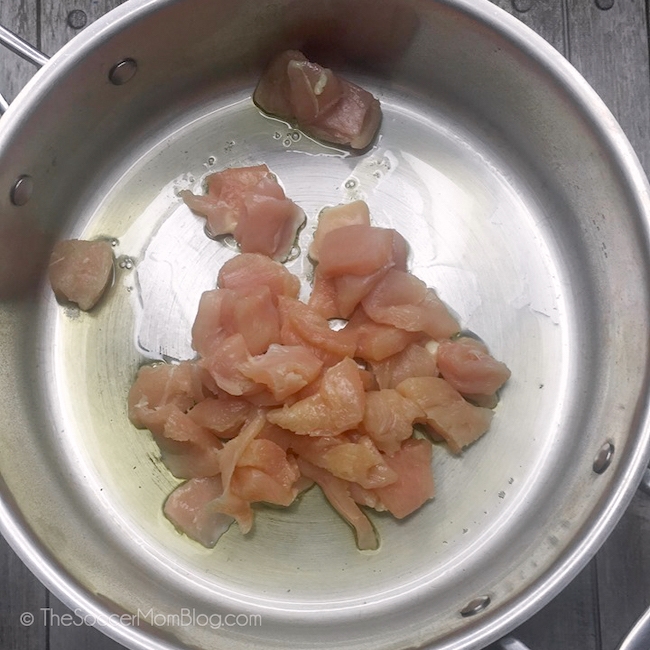 sautéing cubed raw chicken breast in pan with oil