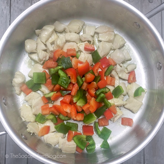 cooking cubed chicken with red and green peppers