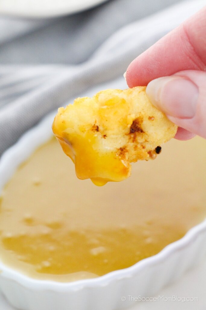 dipping a chicken nugget in honey mustard
