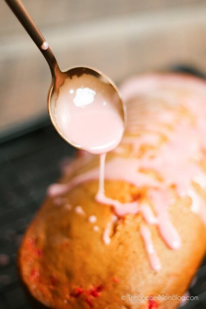 drizzling cherry glaze on fresh baked sweet bread