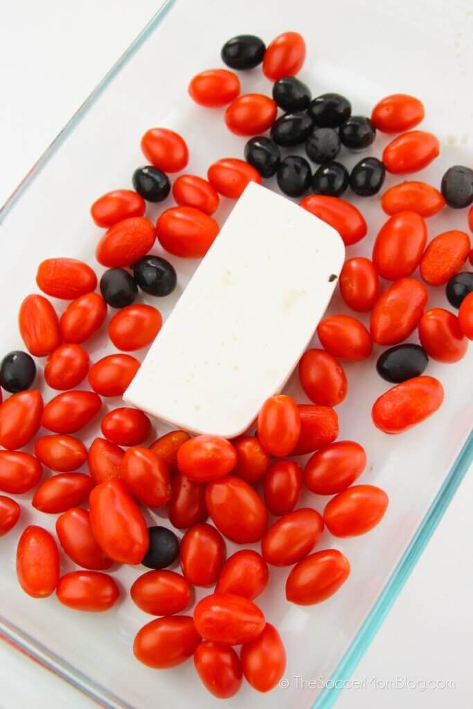 feta cheese, tomatoes, and olives in a glass baking dish
