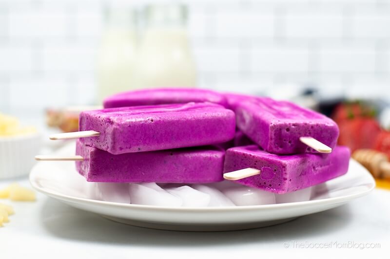 Pile of dragon fruit popsicles on a plate viewed from the side