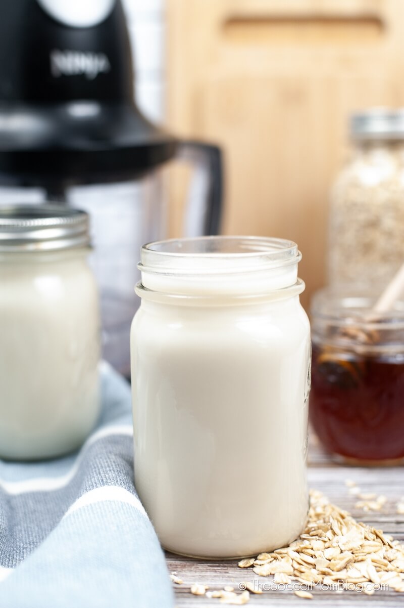 Homemade Oat Milk in a jar, with ingredients on counter