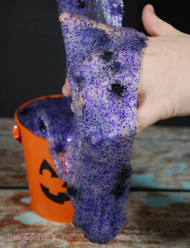 purple glitter slime with toy spiders