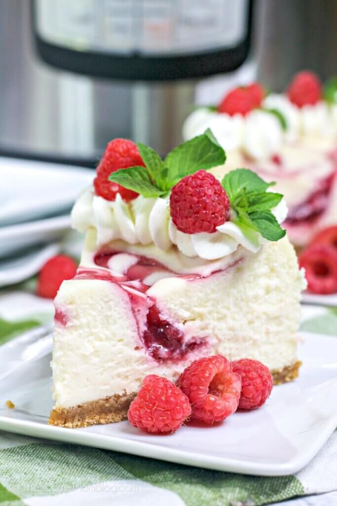 A slice of Instant Pot Raspberry Cheesecake with fresh raspberries on top