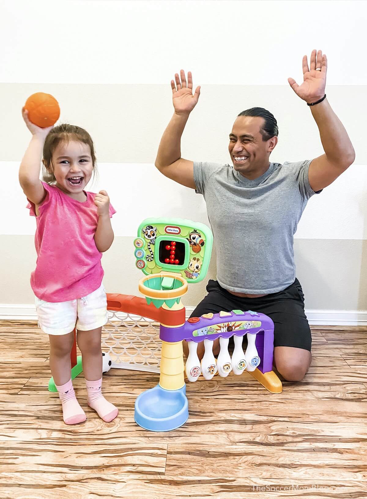 little girl playing basketball with her dad