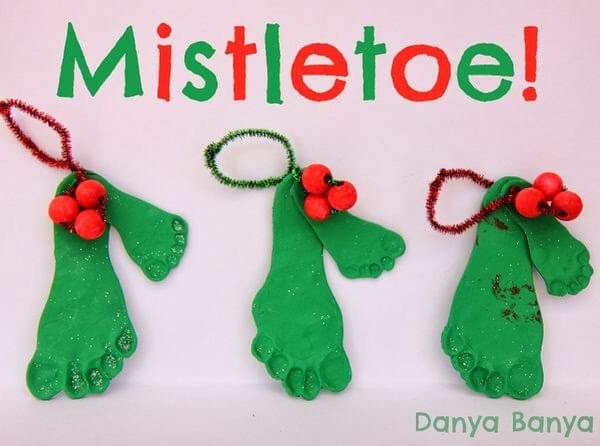 green child footprint craft decorated to look like mistletoe