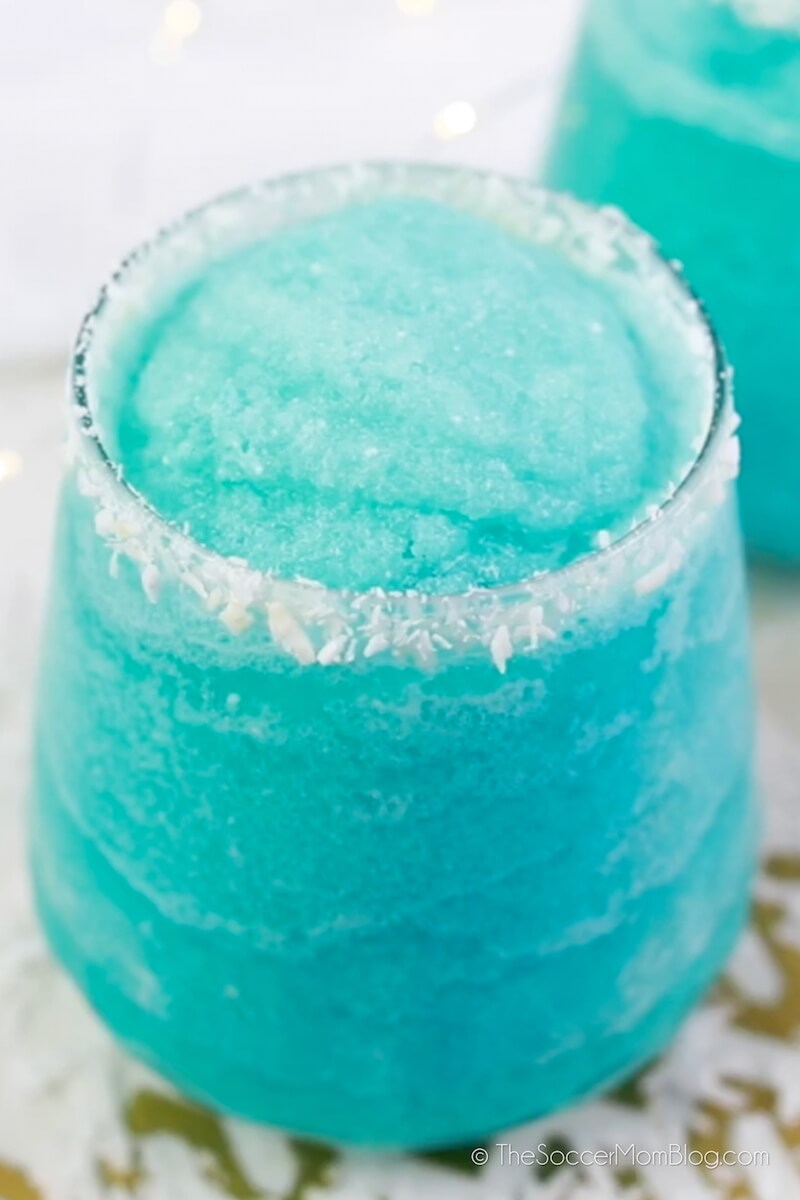 close up of an icy blue cocktail with coconut rim
