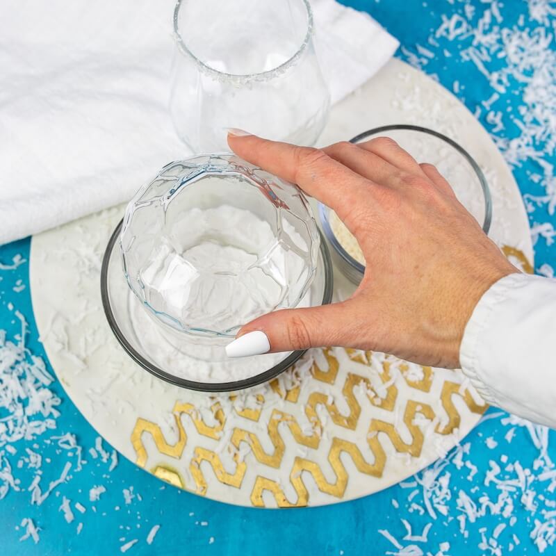 photo showing how to rim a cocktail glass with coconut flakes