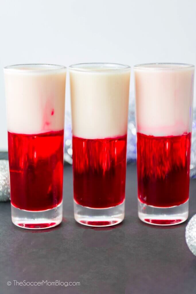3 shot glasses with red and white layered Santa themed shooters