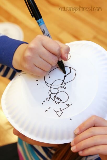kids drawing on a paper plate on his head