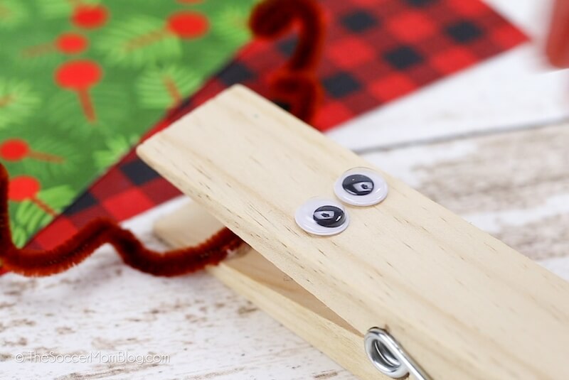 attaching eyeballs to a clothespin to make a reindeer face