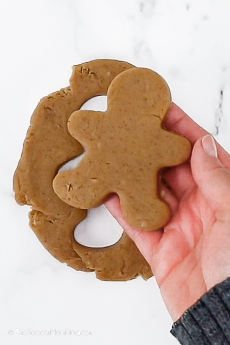cutting a gingerbread man out of playdough