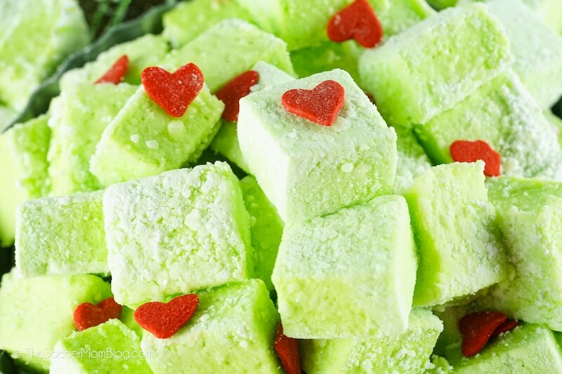 A Pile of homemade green Grinch Marshmallows (green squares with red heart sprinkles0
