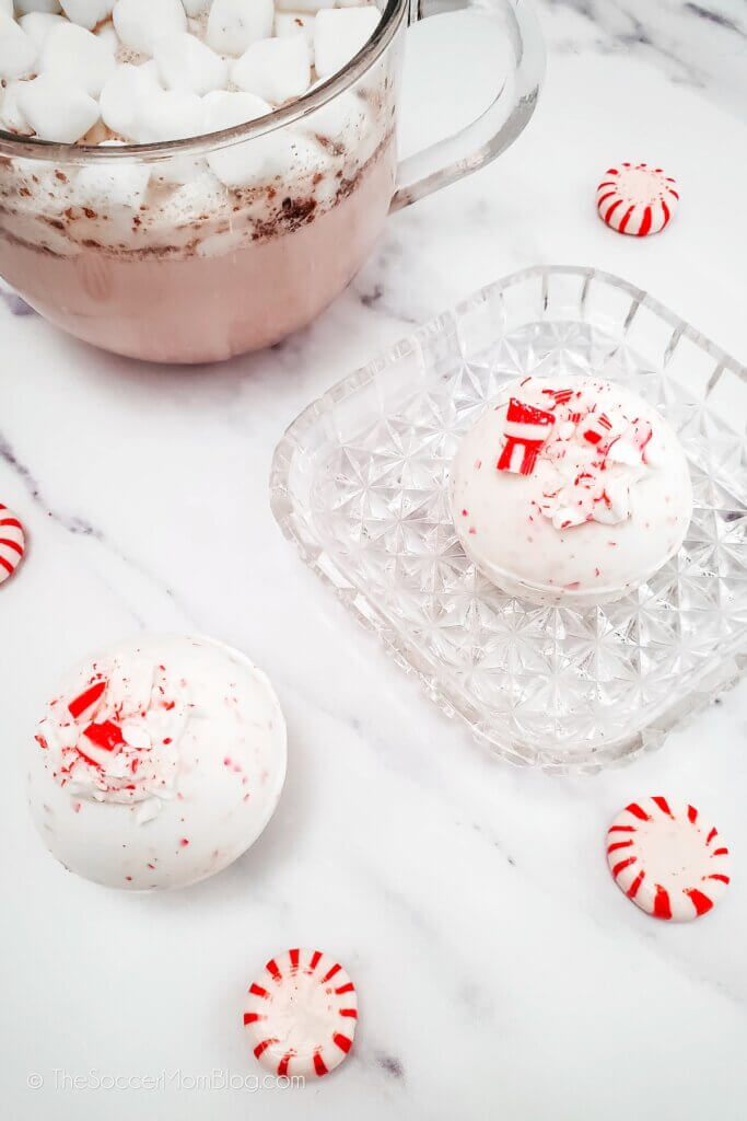 Peppermint hot cocoa bombs with a mug of hot cocoa