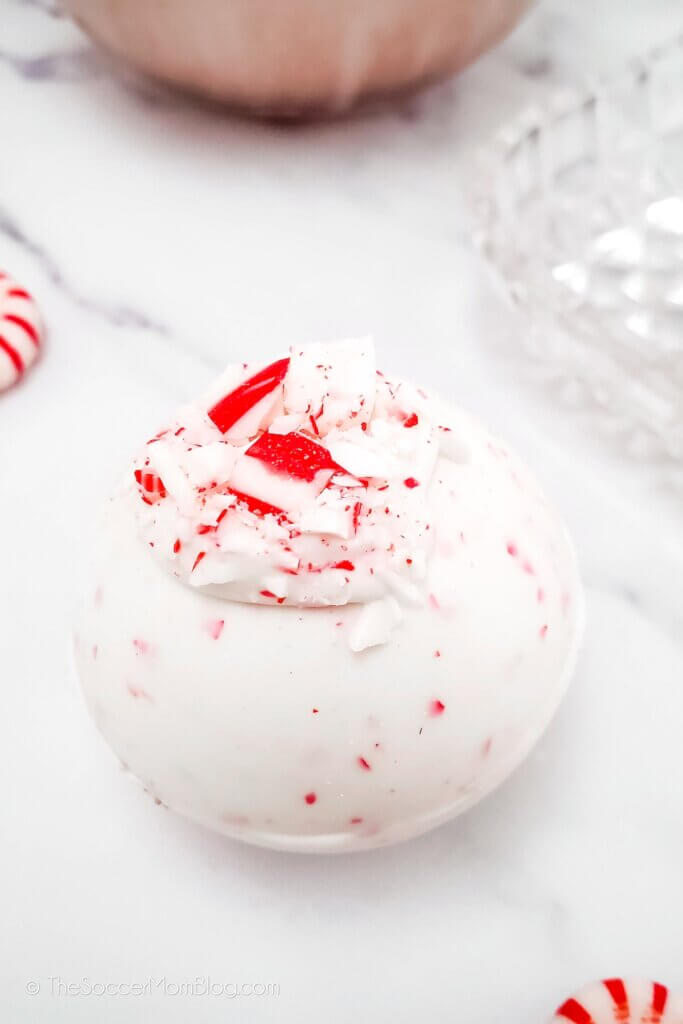 close up of a Peppermint hot cocoa bomb with crushed candy canes