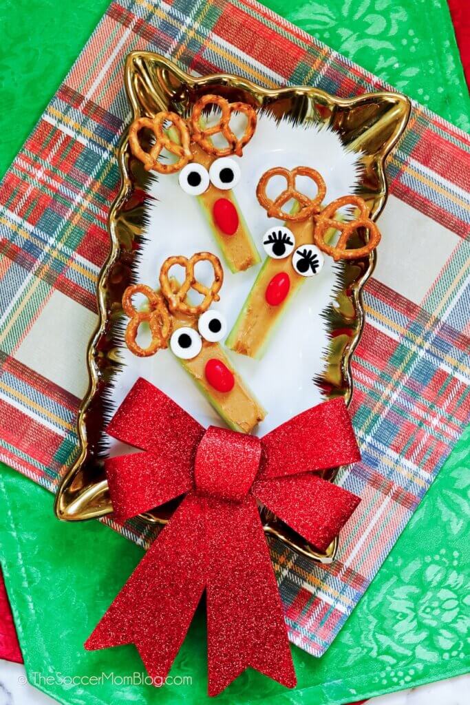 celery sticks filled with peanut butter decorated to look like Rudolph