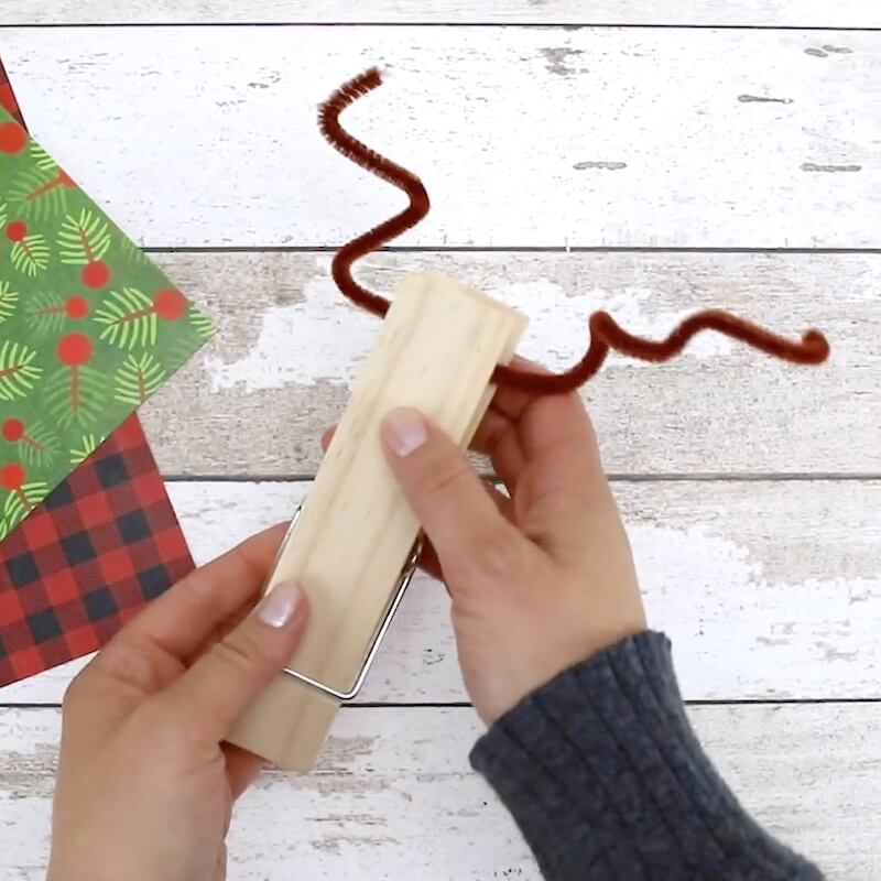 holding a clothespin decorated to look like a reindeer