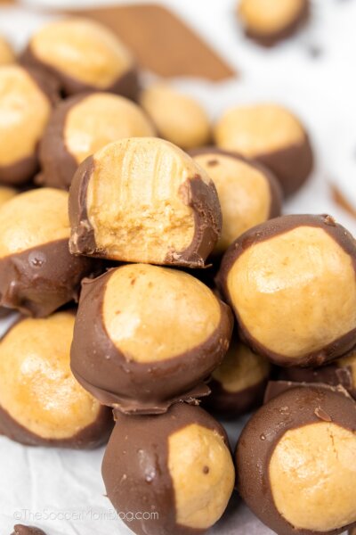 pile of homemade Buckeye Candy (peanut butter balls dipped in chocolate), one with a bite missing.
