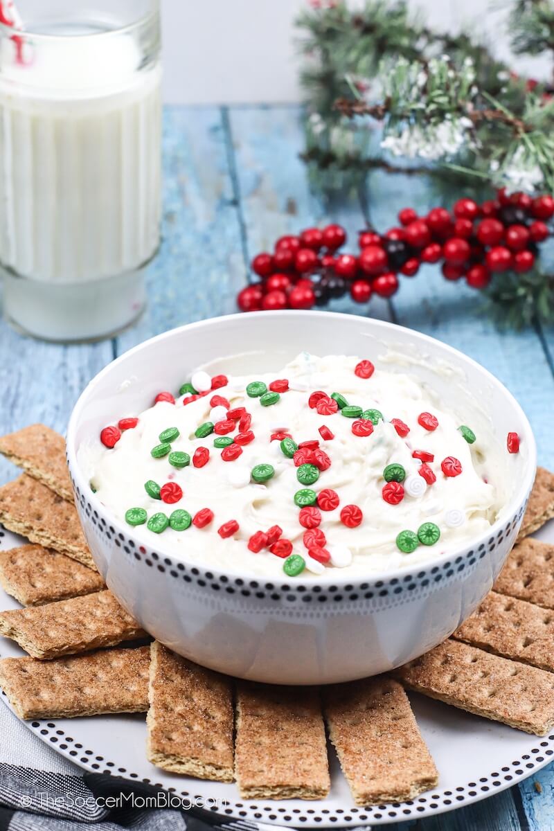 bowl of cookie dip with Christmas sprinkles and graham crackers on plate