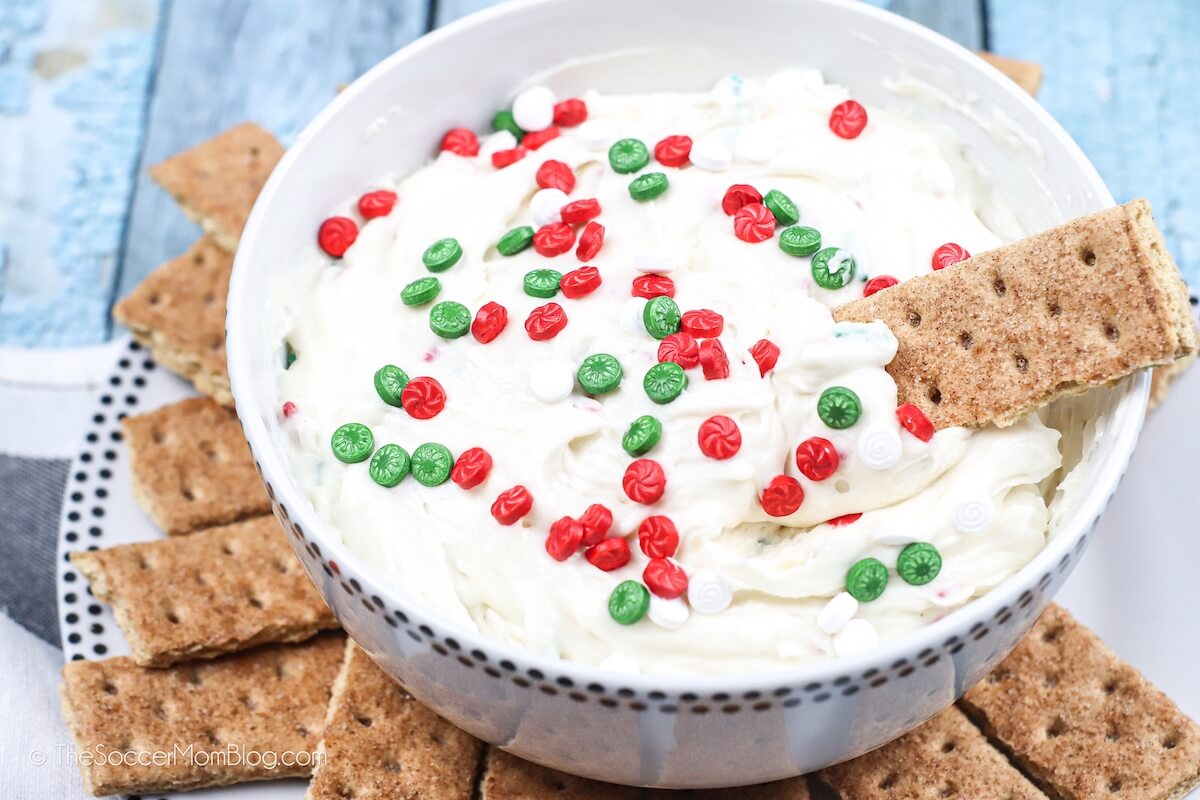dipping graham cracker into Christmas cookie dip