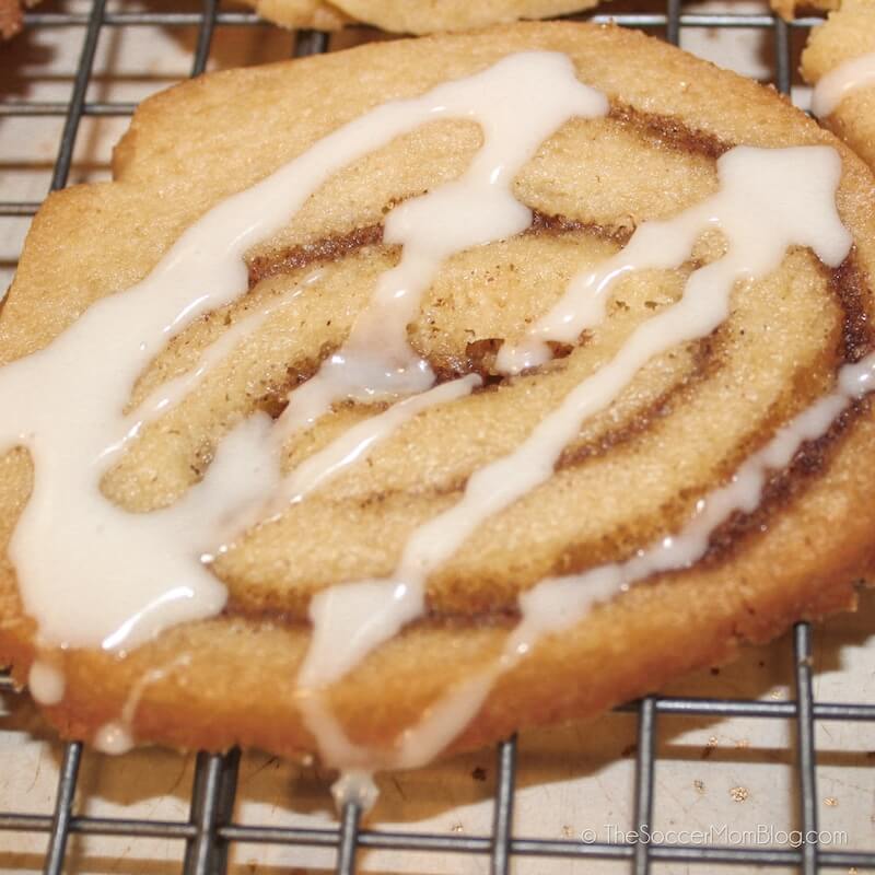 close up of a freshly baked cinnamon cookie with drizzle of icing
