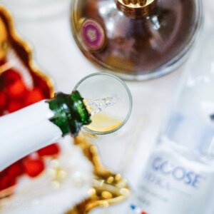 top down shot of pouring champagne into glass flute