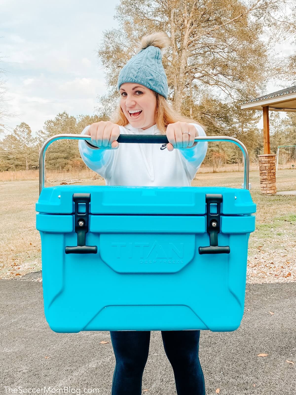 woman holding bright blue portable ice chest cooler