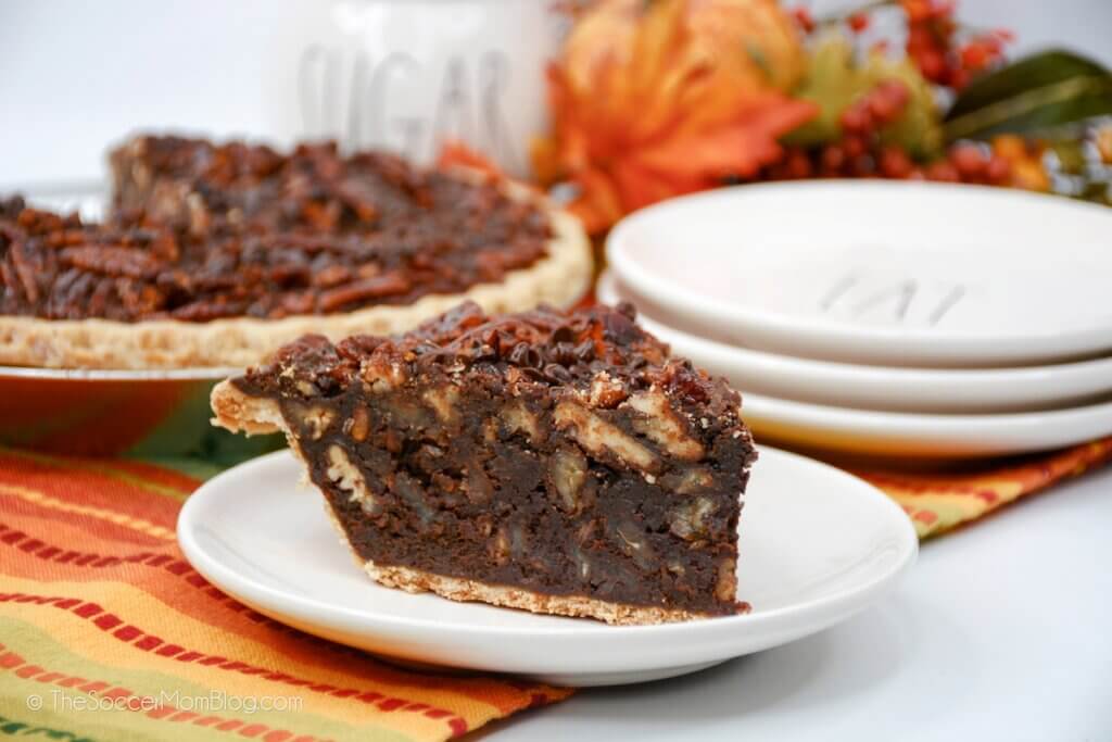 slice of pie filled with fudge and pecans, whole pie in background