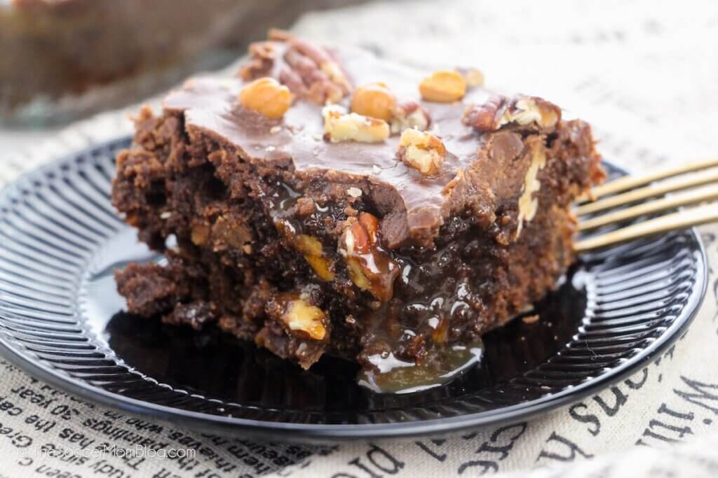 gooey turtle brownie on serving plate with fork