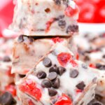 stack of homemade white chocolate fudge squares with cherries and chocolate chips