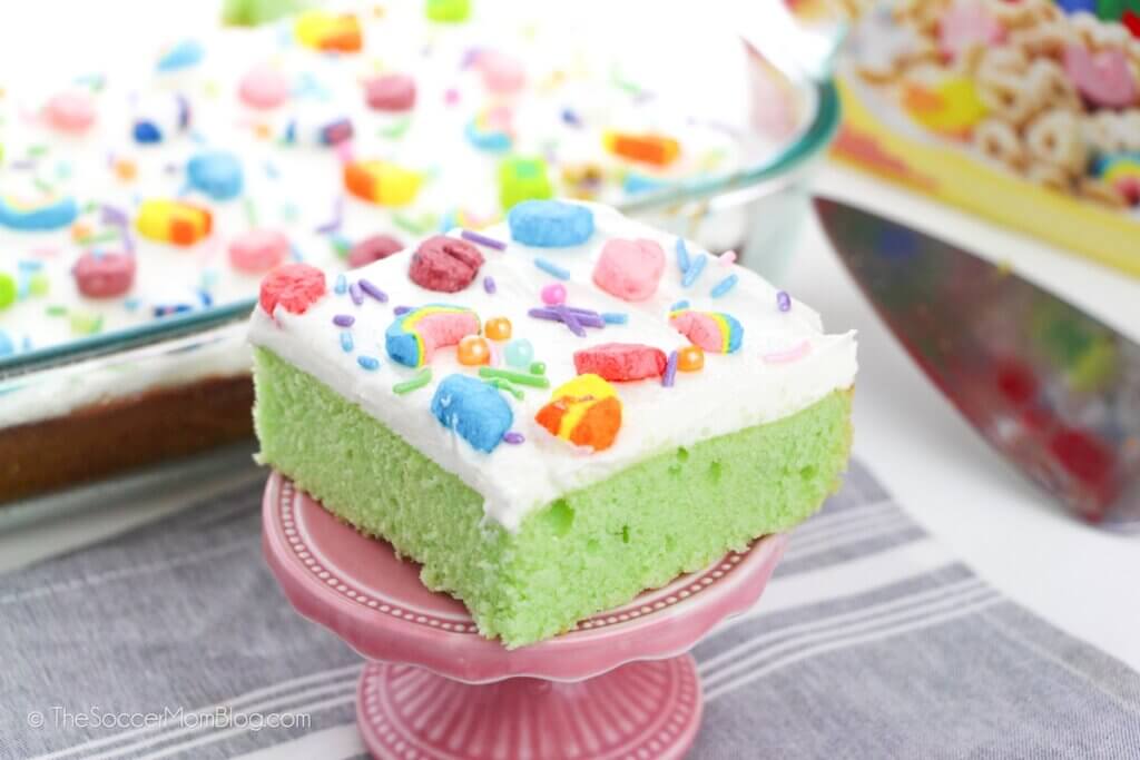 slice of green sheet cake topped with white frosting and Lucky Charms marshmallows