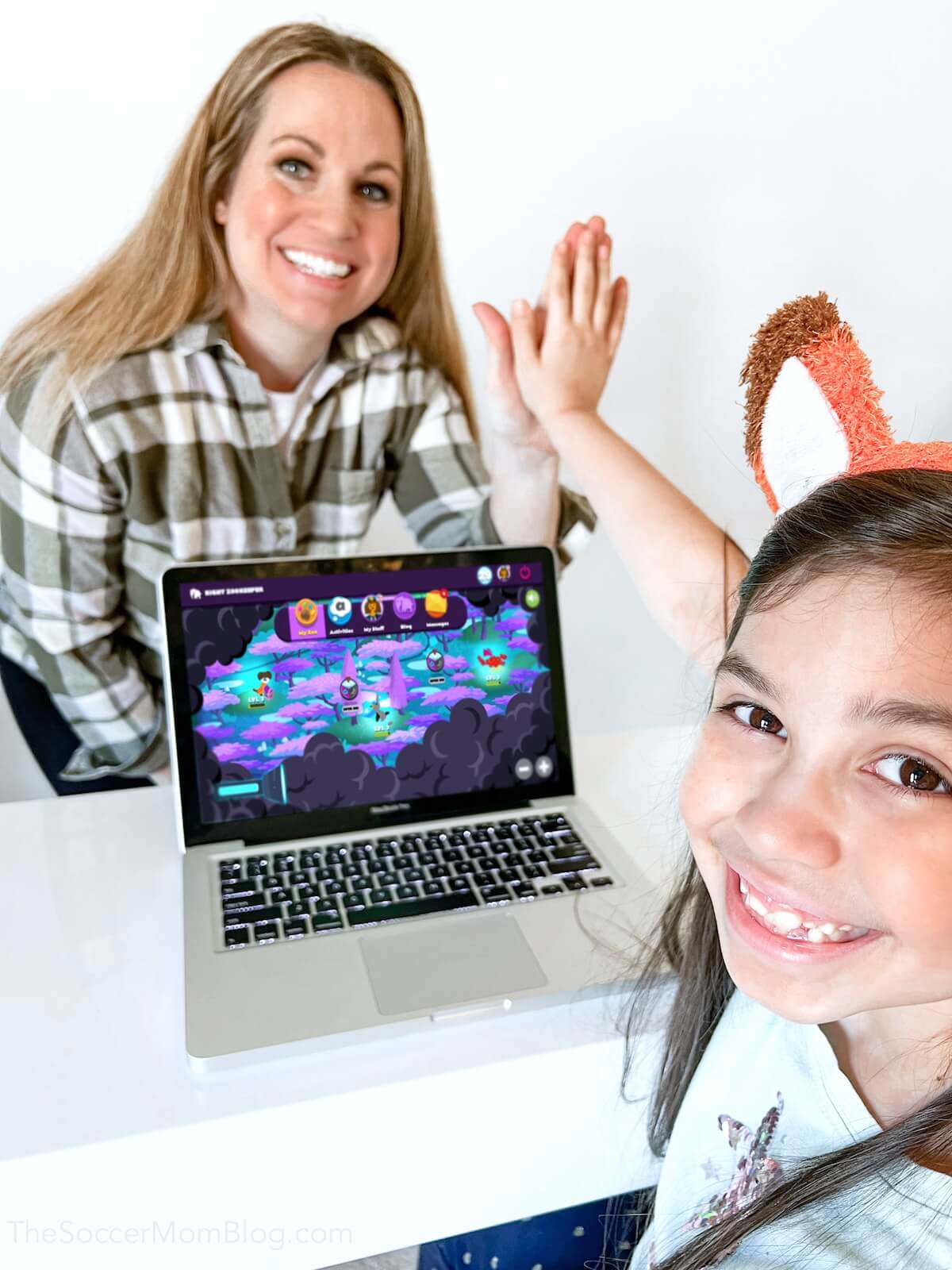 mom and daughter high-fiving with laptop