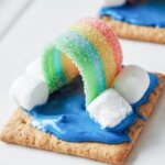 graham crackers frosted to look like a sky with a rainbow