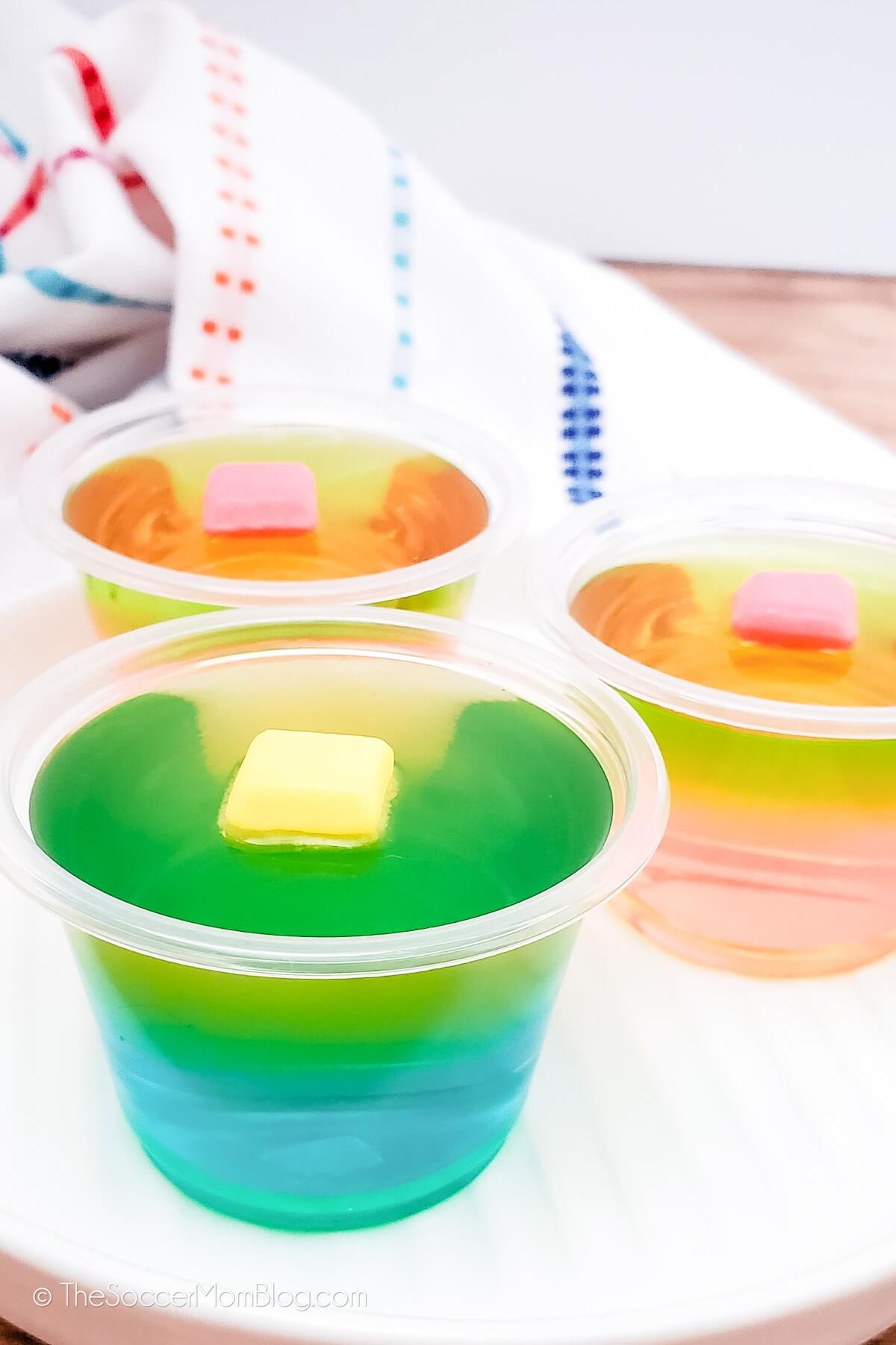 two different kinds of layered jello shots with starburst candy on top