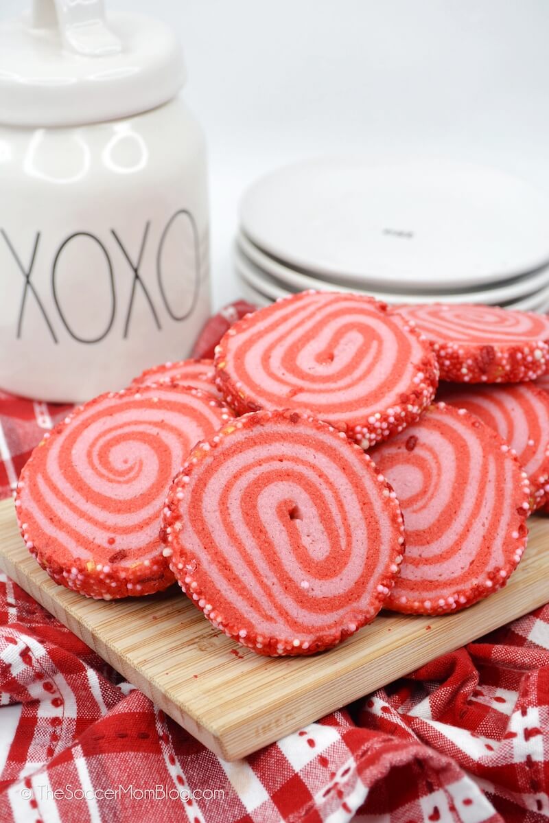 plate of Valentine's Day pinwheel cookies on platter, with cookie jar in background