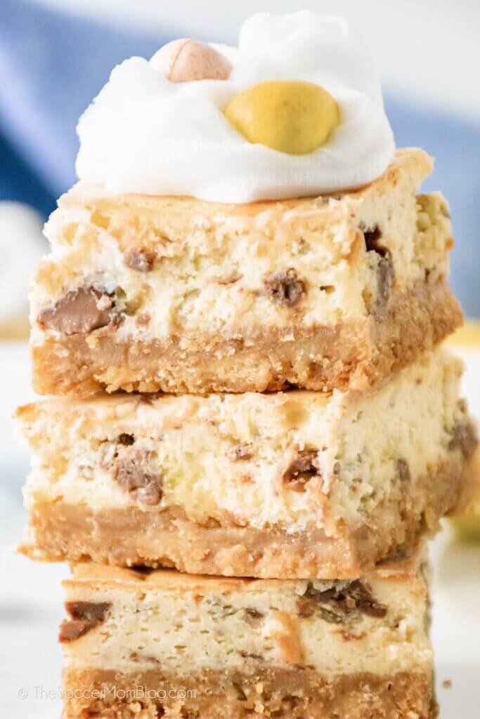 stack of Cadbury Mini Egg Cheesecake Bars topped with whipped cream
